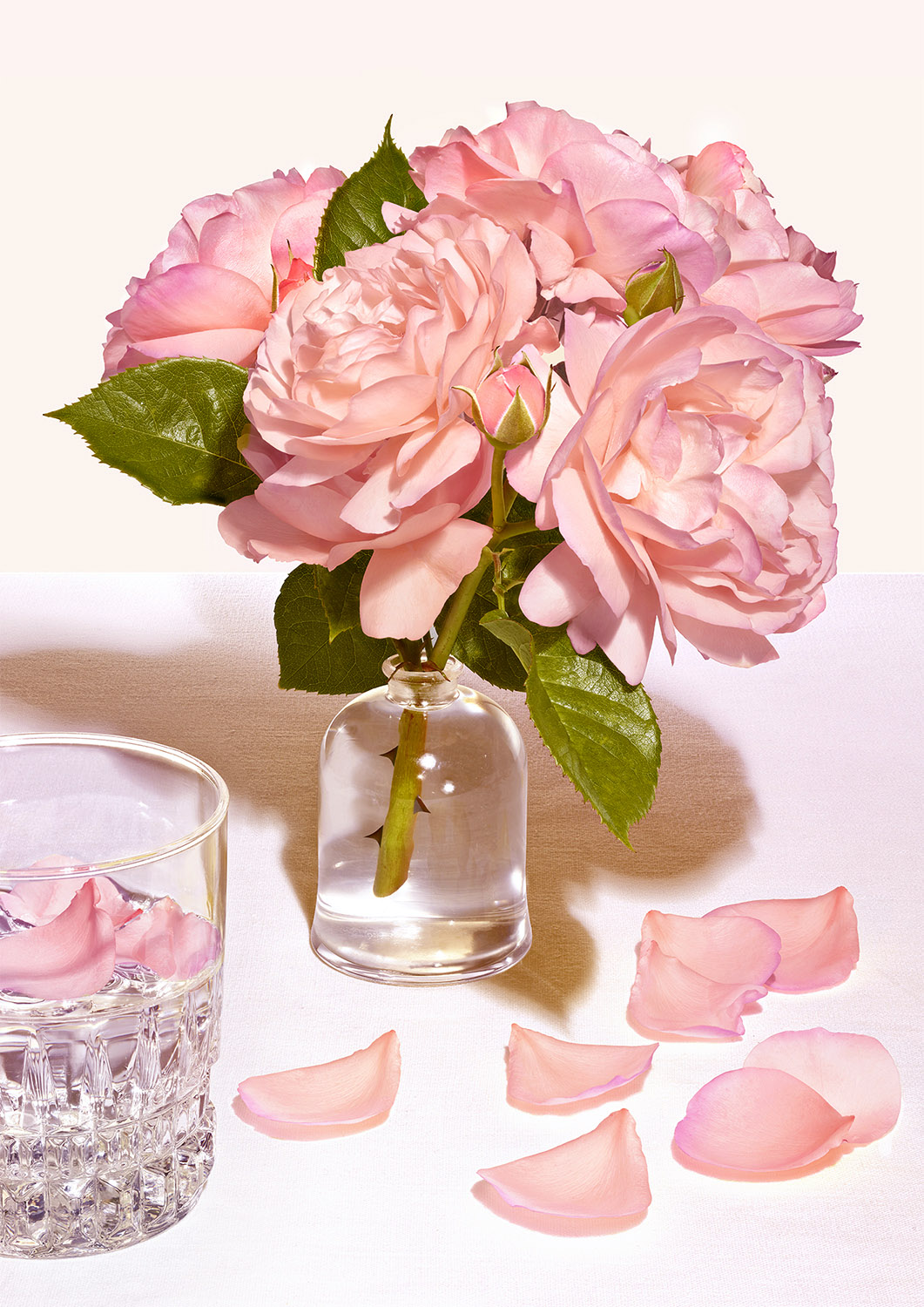 des roses dans un flacon en verre