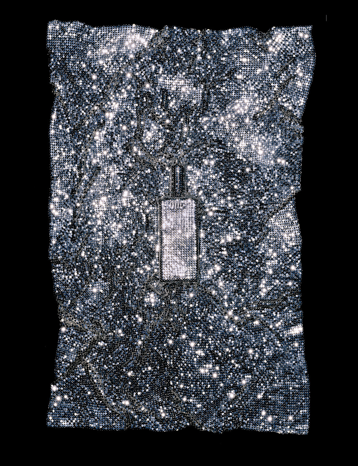 Parfum Koto de Shiseido caché sous un tissu métallique